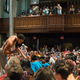 A model kisses the hand of an audience member as screams fill the chapel.
